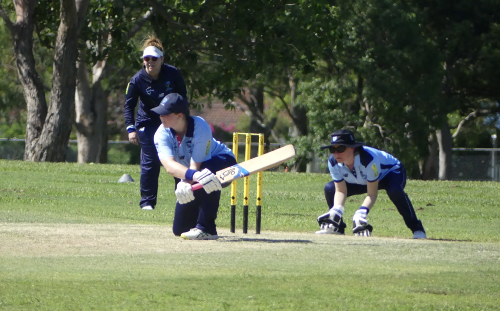 Women's Blind Cricket player in the motion of batting during a State representative match